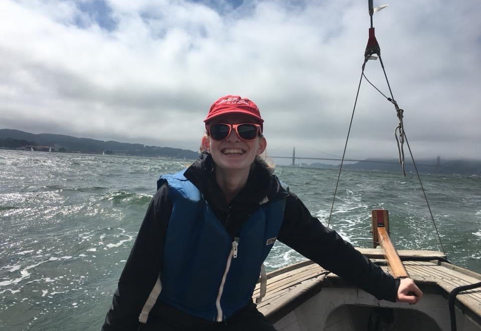 Photo of Charlotte Brownstone on the helm of Sea Scout Ship Viking sailing vessel