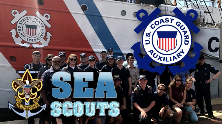 Group of members of Sea Scouts and the Coast Guard in front of a Coast Guard boat