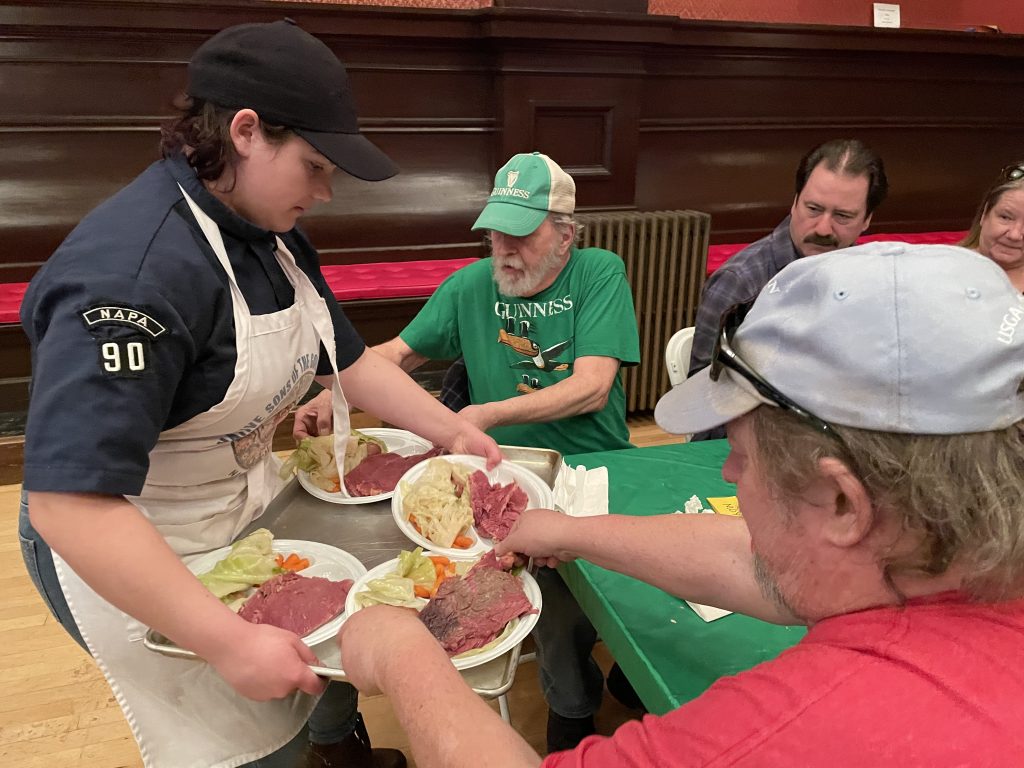 Chaser scout serving dinner at St. Patrick's Day dinner
